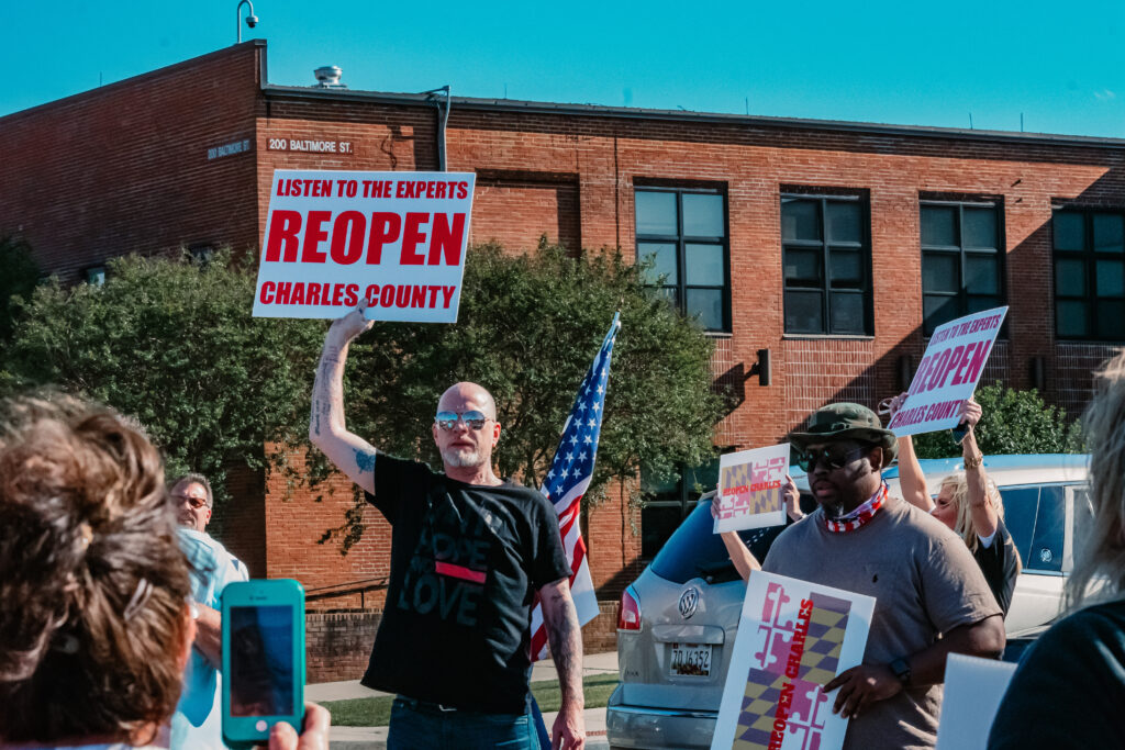 A rally attendee holds his sign up at the Rally to Reopen.