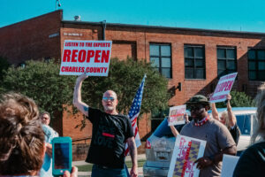 A rally attendee holds his sign up at the Rally to Reopen.